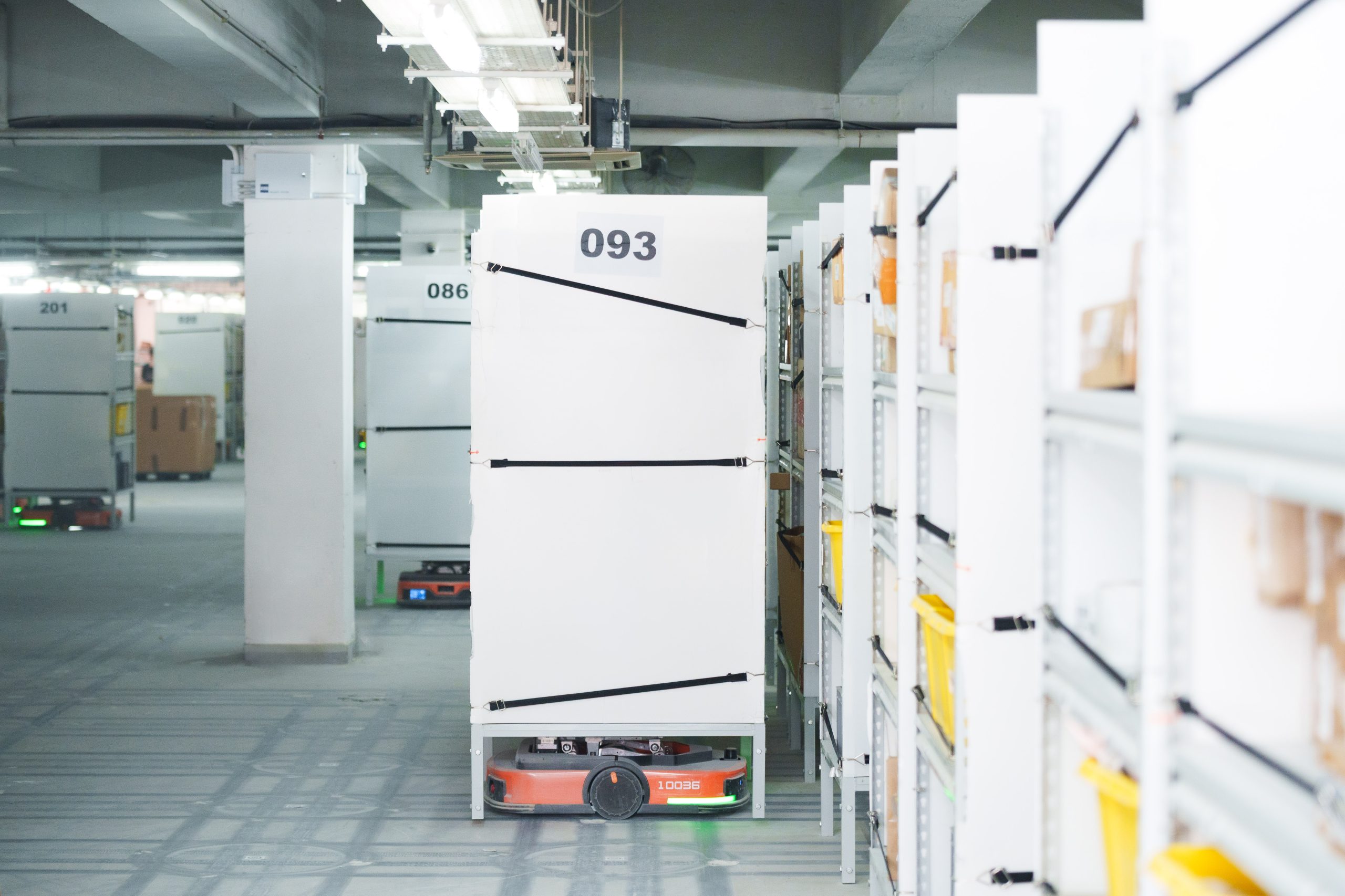 Automated robot carrying a storage rack through the warehouse